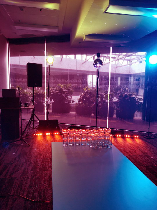 Tematiska ofisa ballīte ar dekorētiem darba galdiem disko stilā un deju gaismām