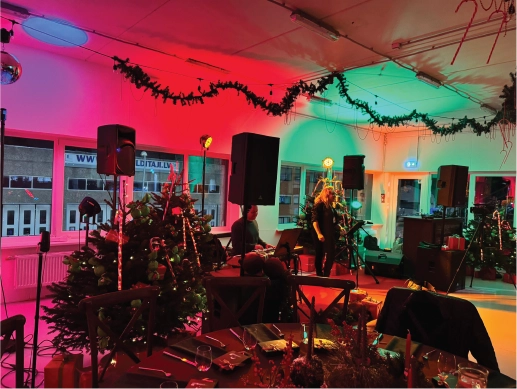 Jaungada balle uzņēmuma telpās pie svētku galdiem ar dzīvo mūziku